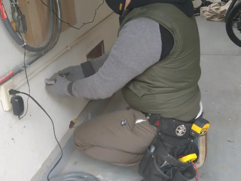 Electrician performing outlet wiring in a Sierra Vista garage
